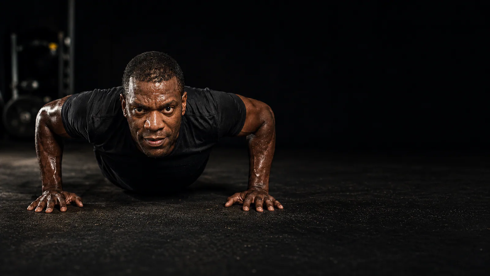 PU365 founder performing a controlled push-up in a dark training studio